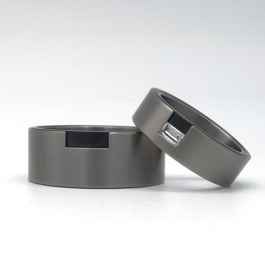 Brede titanium trouwringen met baguette diamant en zicht op zwarte zirkoniuminleg