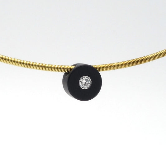 Zwarte zirkonium hanger van 7,5 mm met witte diamant van 0,05 ct, aan een goudkleurige spang.

